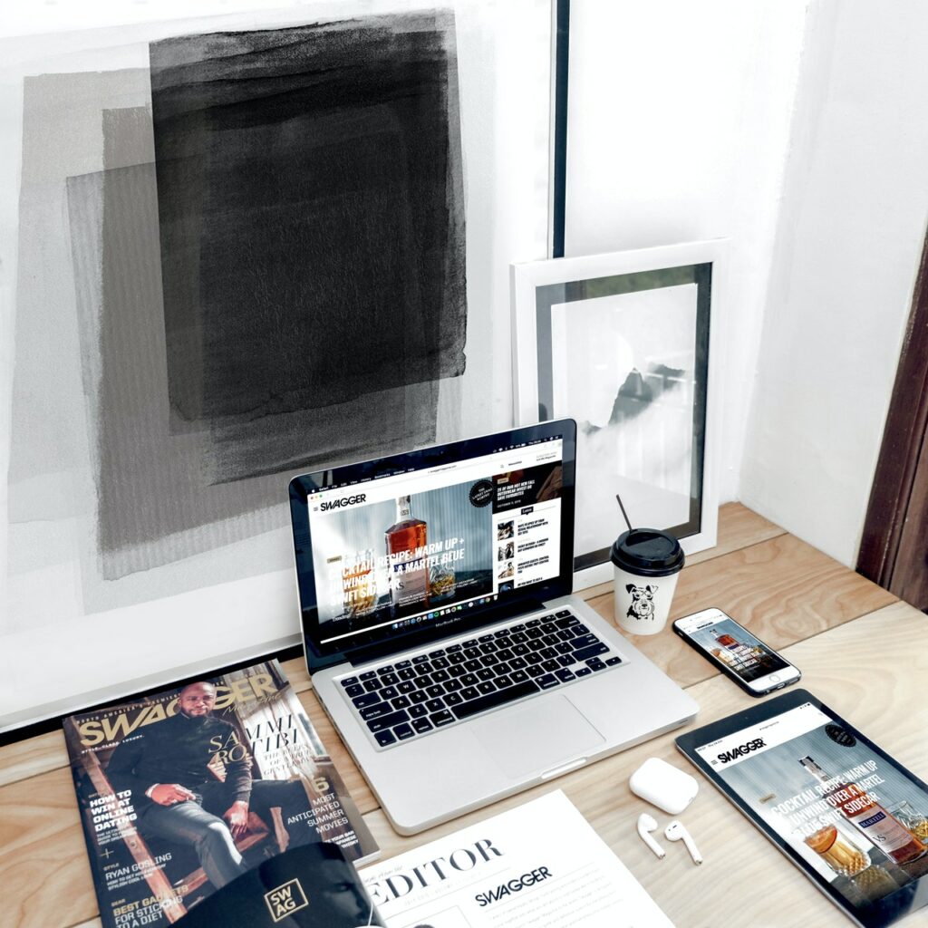 MacBook Computer Surrounded By Assorted Items On A Desk