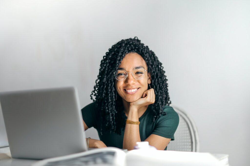 happy woman sitting by a desk with laptop